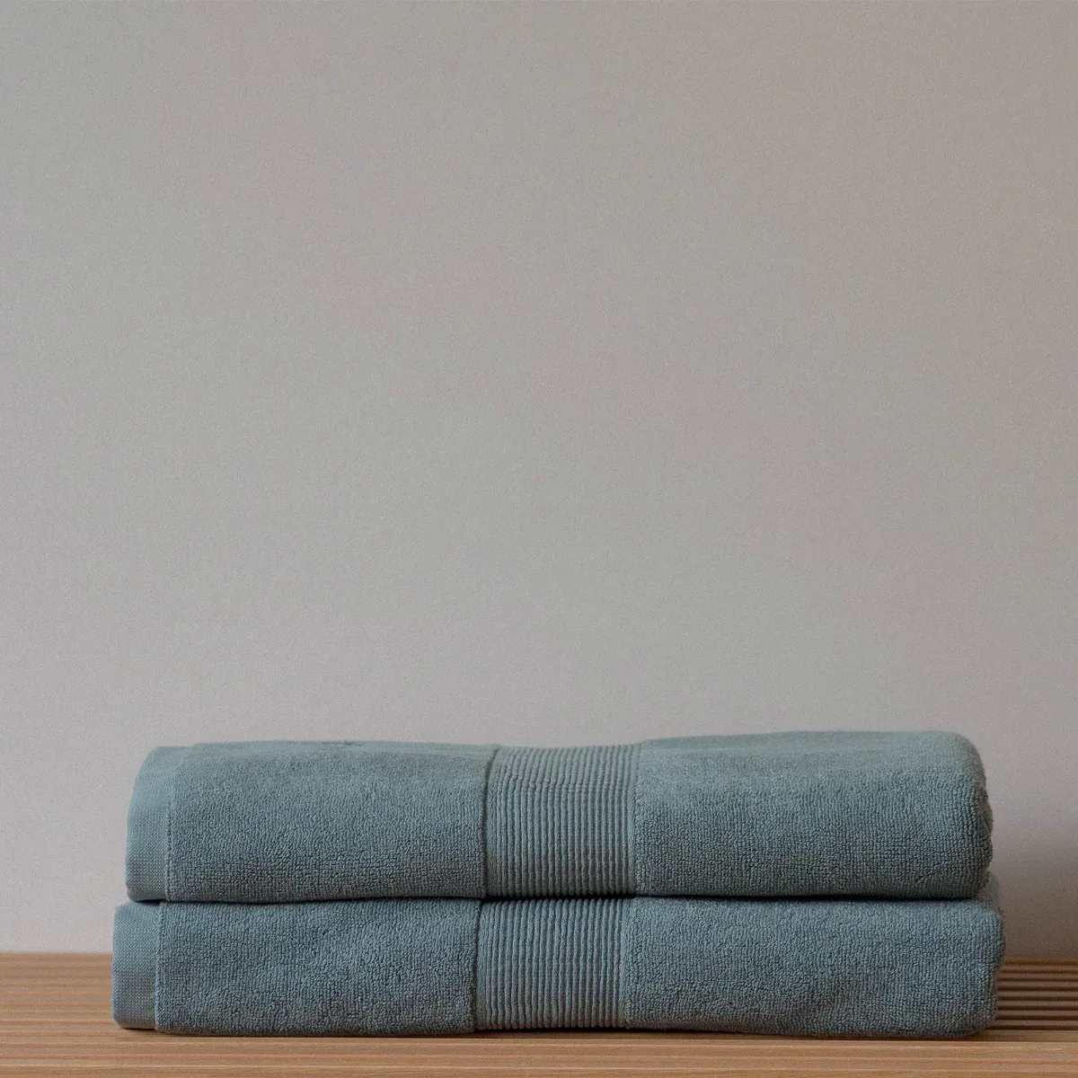 Folded teal towels on wood