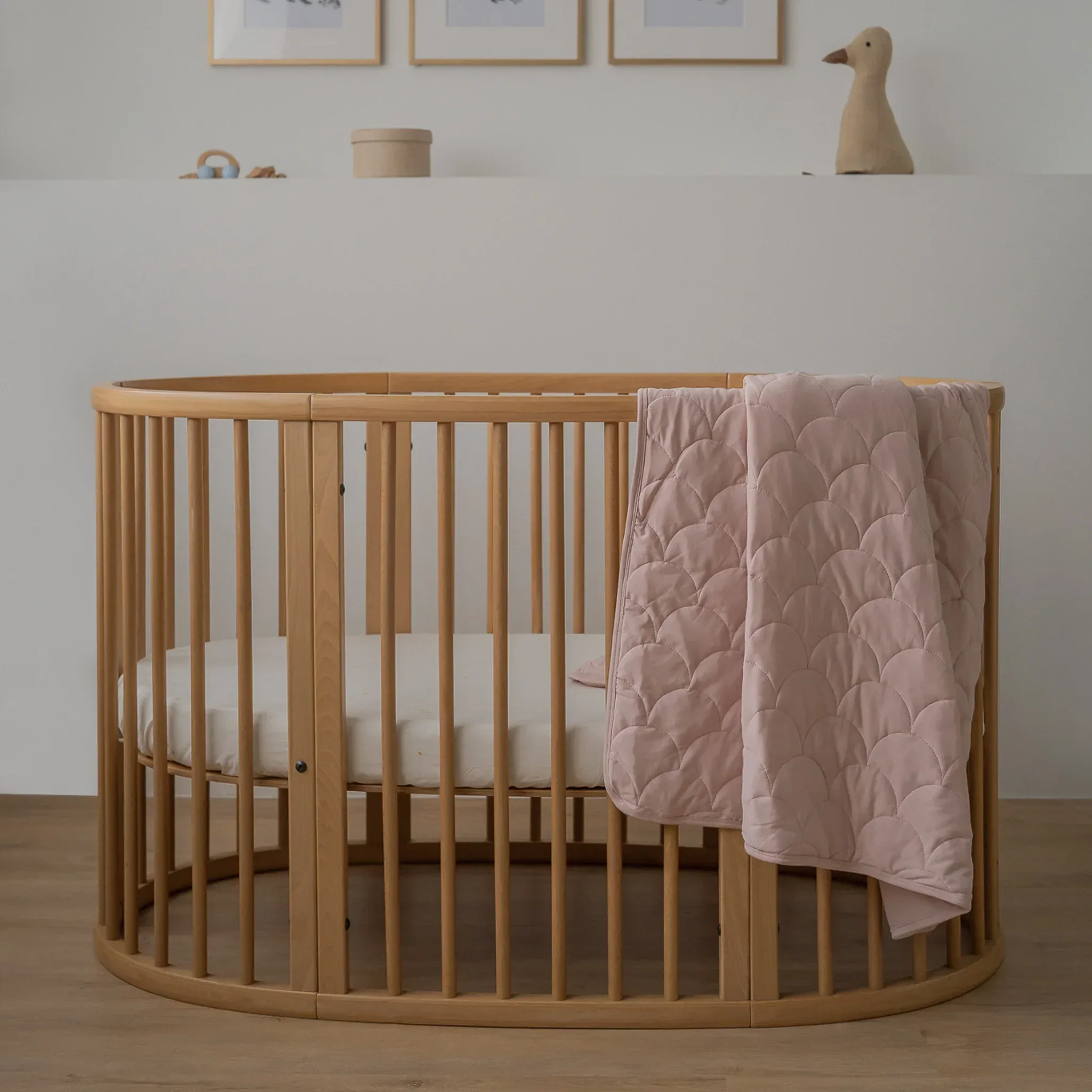 Nursery crib with quilted blanket