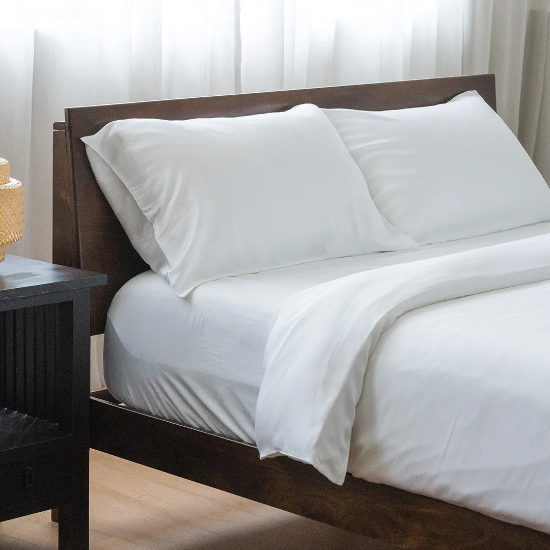 White bedding set on walnut frame